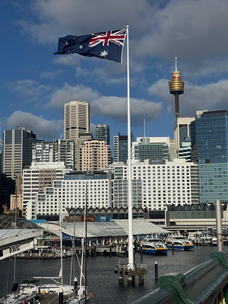Darling Harbour com a bandeira australiana e a Sydney Tower ao fundo